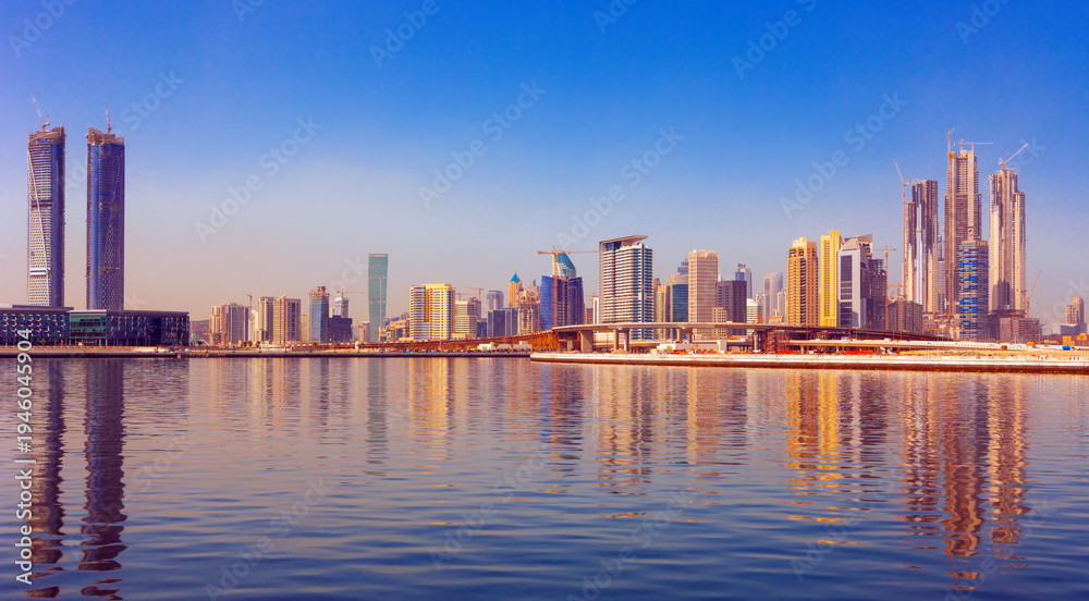 Obraz premium Panoramic skyline of Dubai with modern skyscrapers and futuristic architecture at sunset. Iconic cityscape of the largest city in the United Arab Emirates, famous for luxury tourism, business district