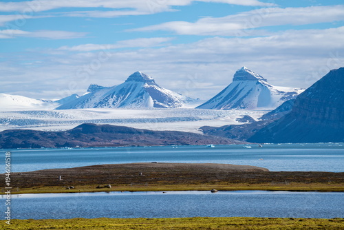 Bay on the base of snow covered mountains, across from the research station at Ny Alesund, Svalbard, Norway