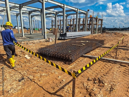 Photos View on rusty square reinforcement for concrete, construction site is in background