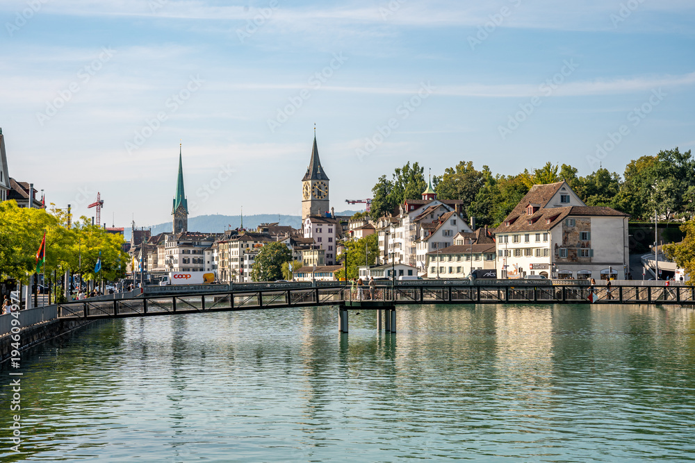 Fototapeta premium Scenic city view with church bell towers and the Limmat river seen from Muhlesteg bridge in Zurich, Switzerland.