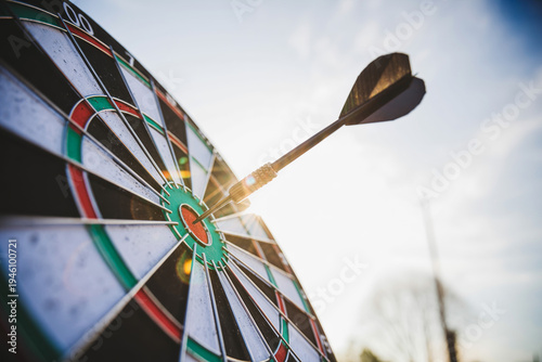 Dartboard with dart hitting bullseye, representing successful goal achievement and precision