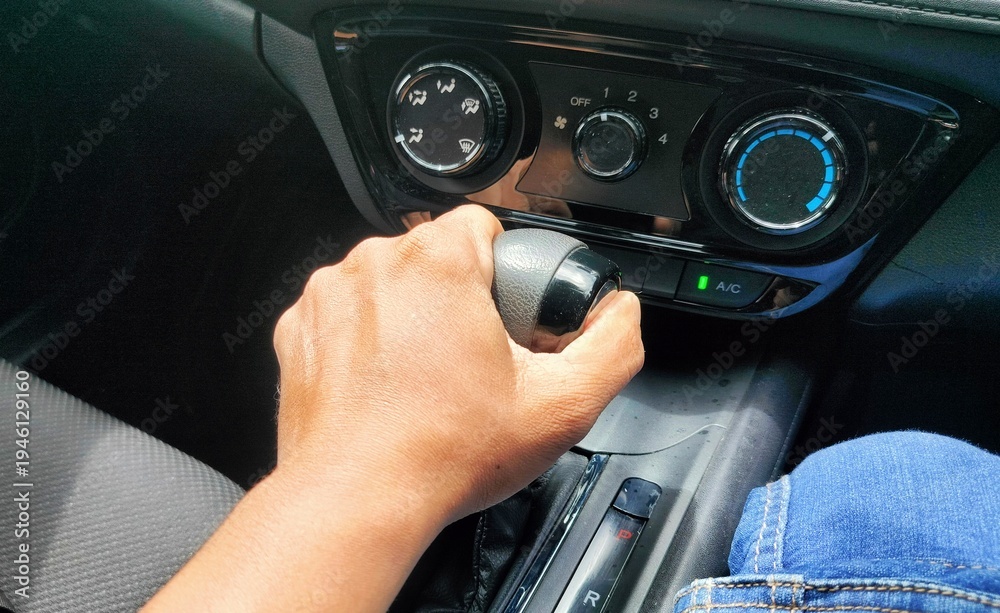 Naklejka premium how to enter car gear by pressing the button. driving a car. hand of man on gear auto in car. hand changing gear while driving car.
