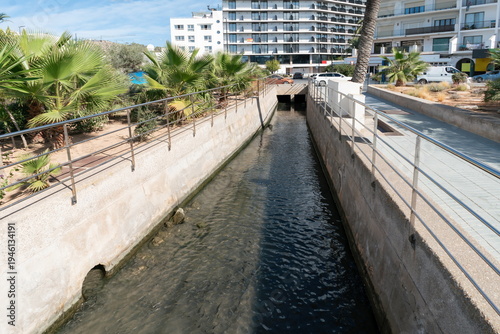 Canvastavla Urban water channel in Ibiza Spain with palms and apartments