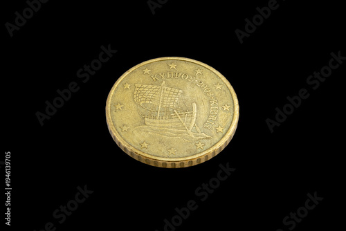 Tilted obverse view of a 2008 Cypriot 50 cent coin featuring the ancient Kyrenia sailing ship. Country name in Greek and Turkish means 