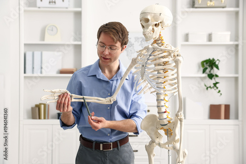 Tableau sur toile Teacher demonstrating human skeleton model in classroom