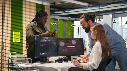 Fotografija Young programmer in office requests help from IT experts detecting and blocking hacker intrusion