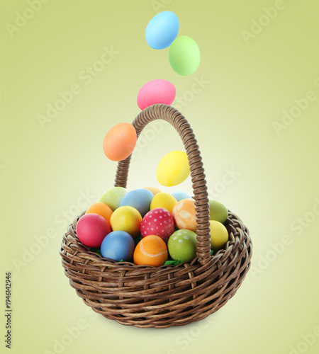 Happy Easter. Painted eggs falling into wicker basket on green gradient background