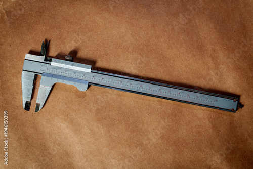 Konstfotografi Vernier caliber precision measuring tool with brown paper background
