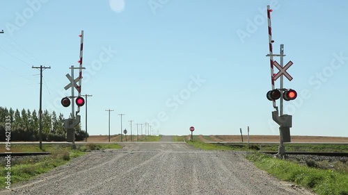 Rail crossing with sound of train coming. Gates lowering. Manitoba. HD.