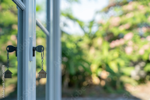 key for unlocking house is plugged into the door. Second hand house for rent and sale. keychain is blowing in the wind. mortgage for new home, buy, sell, renovate, investment, owner, estate