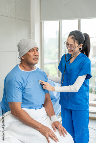 A male cancer patient on bed receives IV therapy while a female doctor offers care encouragement and updates on his test results providing support and discussing health progress