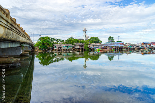 Local fishing village along the Bang Nara River with kolae boats colorful with a mosque in the background in the evening.