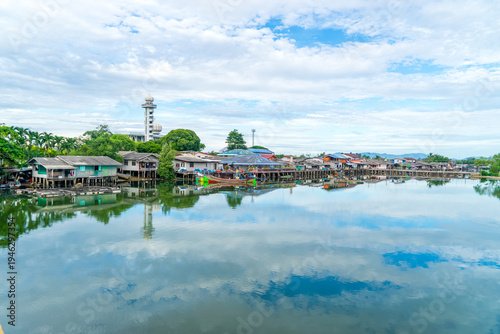 Local fishing village along the Bang Nara River with kolae boats colorful with a mosque in the background in the evening.