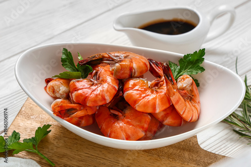 Schilderij op canvas Bowl of tasty boiled shrimps with parsley and soy sauce on white wooden backgrou