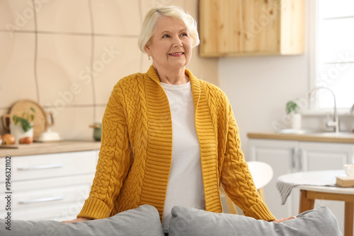 Senior woman behind sofa in...