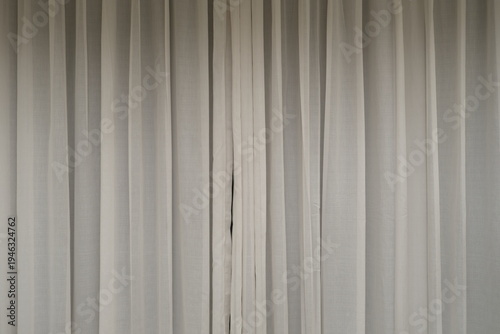 Soft sheer white curtains with vertical folds create a calm minimalist interior background, perfect for hotel, bedroom, and design copy space.