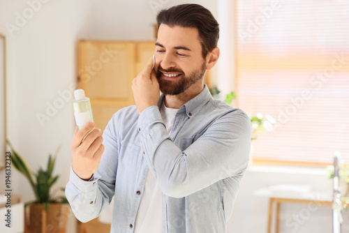 Handsome man with bottle of...