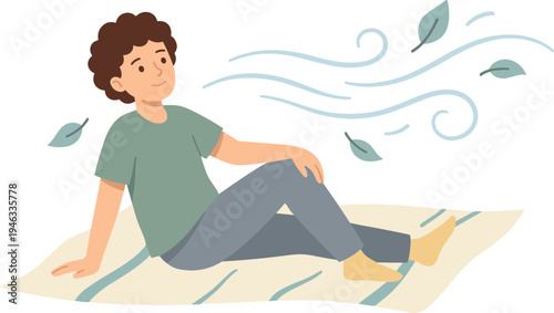 Person sitting on a blanket outdoors feeling the wind with leaves blowing