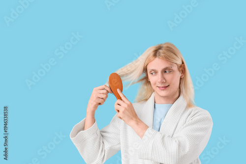 Young blonde man brushing h...