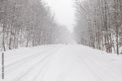 A road covered with snow and ice in winter during a snowfall