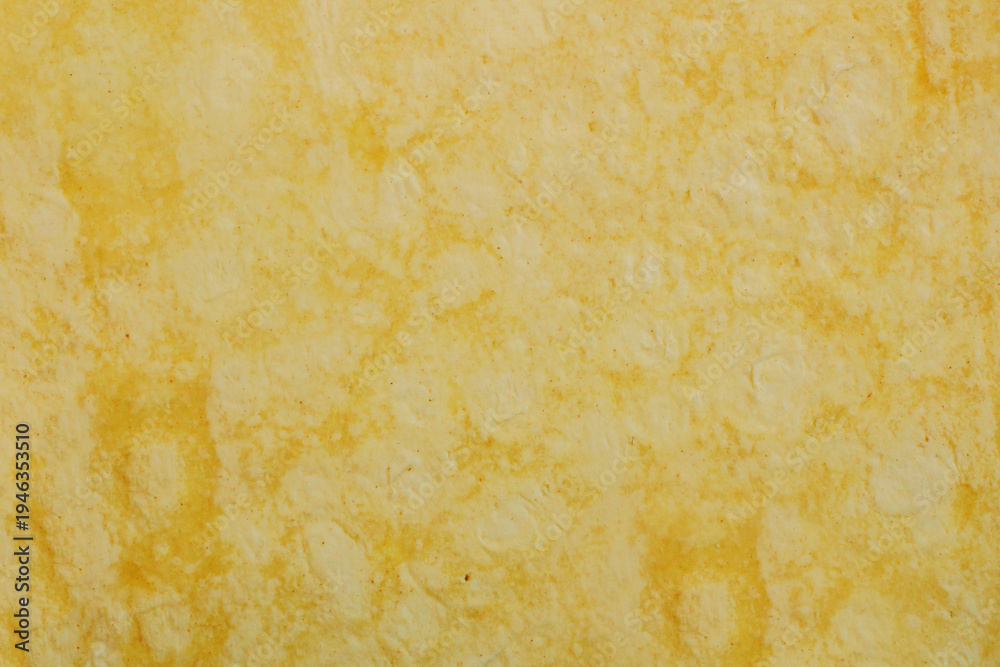 Fototapeta premium Soft, golden-yellow surface with subtle, organic swirls