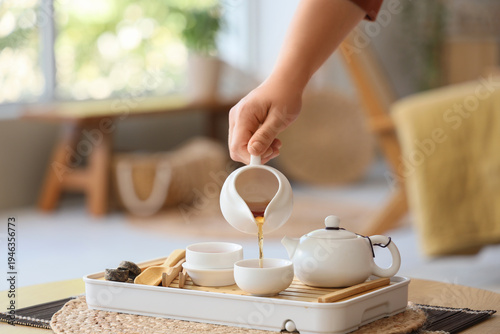 Female hand pouring tea on ...