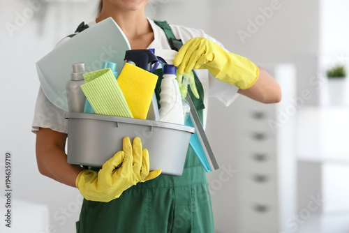 Obraz na płótnie Female janitor with cleaning supplies in office