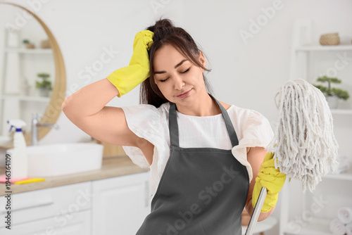 Tired female janitor with m...