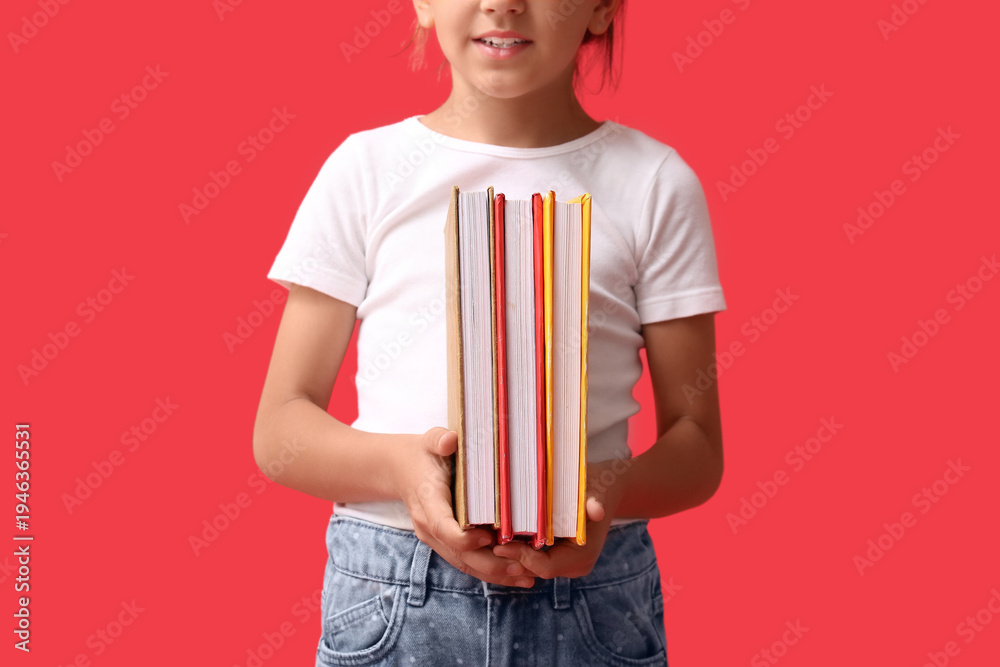 Naklejka premium Cute little girl holding books on red background