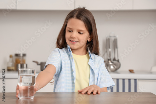 Cute girl taking glass of w...
