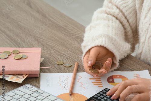 Woman with coins using calc...