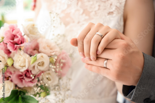 Newlyweds with rings and fl...