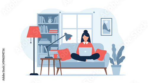 Freelance woman working on her laptop while sitting comfortably on a blue sofa in a modern home office apartment.