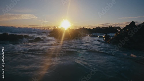Wallpaper Mural Backlit wave crests as sunlight flares by moving water near rocky shore Torontodigital.ca