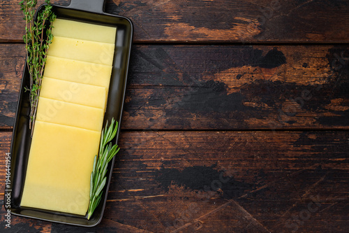 Bild auf Leinwand Stack of semi hard yellow cheese slices arranged on black tray, dairy ingredient