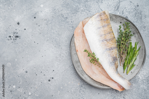 Bild auf Leinwand Raw pike perch fillets with skin and fresh herbs on light background, lean freshwater white fish for healthy cooking