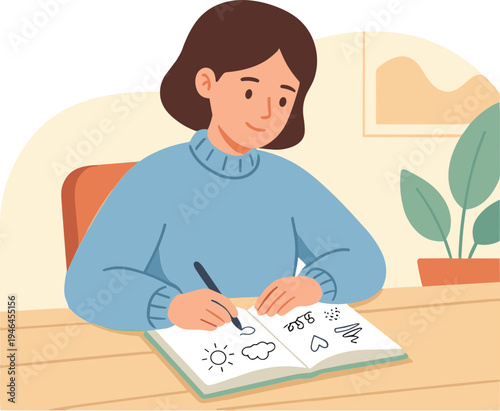 A woman sits at a desk drawing pictures of weather in her notebook indoors.