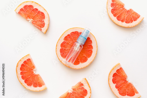 slices of grapefruit. A bottle of perfume against a background of grapefruits. Grapefruits and an empty bottle. Grapefruit perfume.