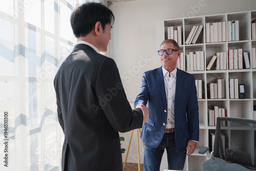 Businessmen shaking hands sealing partnership agreement in office