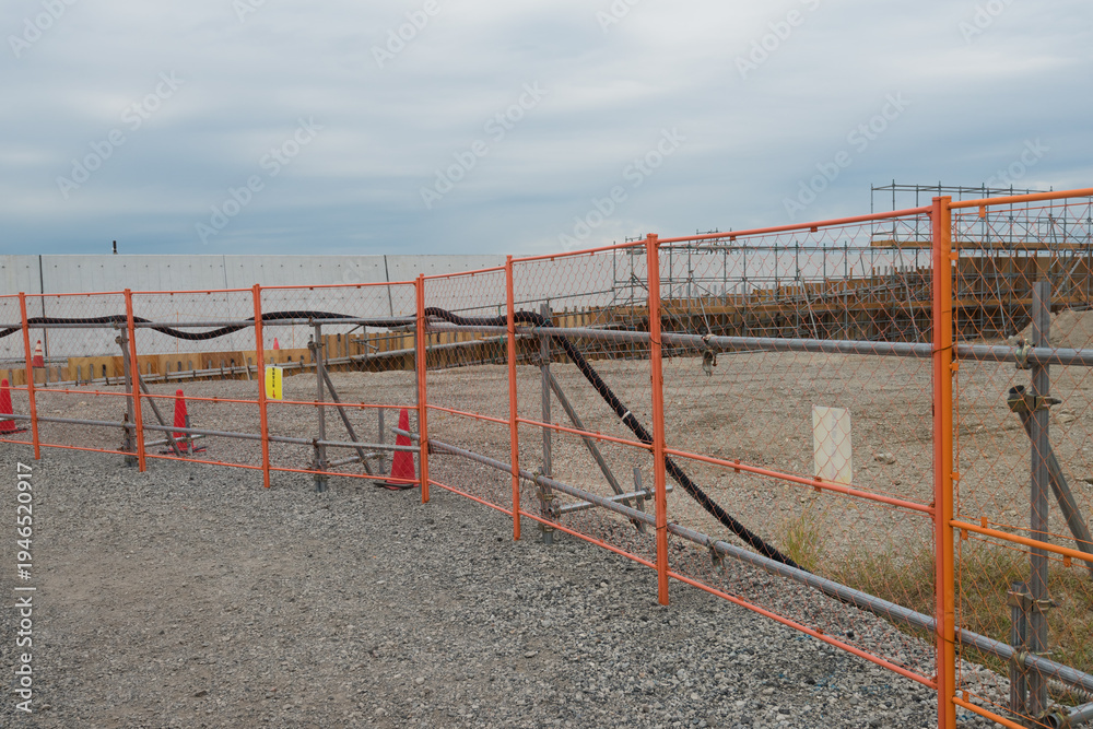 custom made wallpaper toronto digitalOrange safety fences bordering a gravel path at a construction site under a cloudy sky