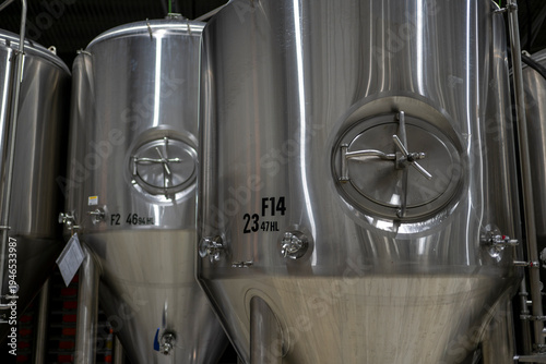 Series of stainless steel fermentation vessels installed in beer production brewery facility showing industrial brewing tanks and beverage manufacturing equipment