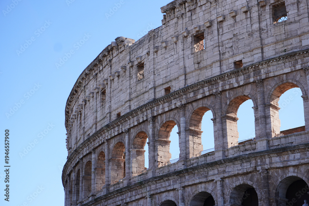 Obraz premium Colosseum (Coliseum) building or Flavian Amphitheatre in Rome, Lazio, Italy. Architectural monument of Ancient Rome. Close up view of the Colosseum, highlighting arches and aged stone. 