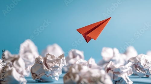 Red paper plane flying high above many crumpled paper balls, symbolizing a successful idea, innovation, leadership, and standing out from failure or rejected concepts.