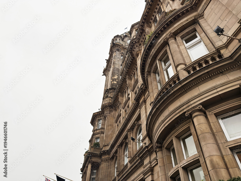 Fototapeta premium Historic sandstone architecture with curved bays and ornate classical details on a Victorian building in Edinburgh, Scotland, UK photographed from street level against an overcast sky