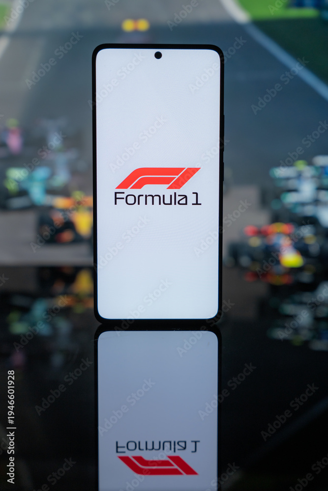 Obraz premium the official Formula 1 logo on a white screen, set against a blurred background of F1 racing cars on a track, representing professional motorsport media and digital broadcast coverage