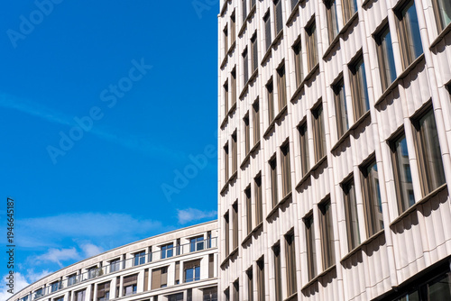 Modern architecture building facade exterior with windows in urban sky featuring reflective office tower corner design and structure with clouds