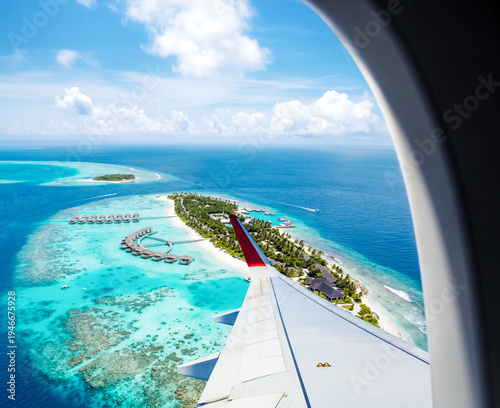 A stunning aerial view of a beautiful island in turquoise ocean seen from an airplane porthole