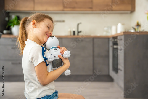Child hugging robotic dog with affection while sitting on sofa at home. Emotional attachment and digital companionship in modern family life.