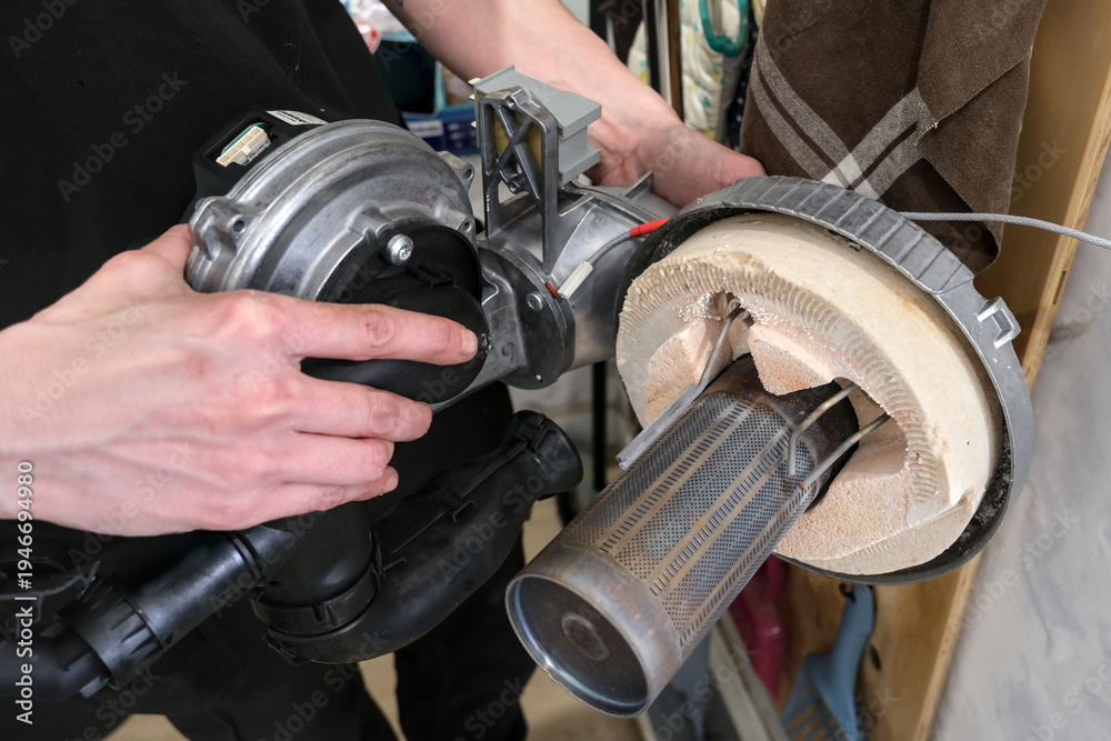 Fototapeta premium Technician hands checking boiler electrodes during annual maintenance inside the heating unit.
