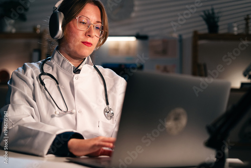 Foto woman doctor working during night shift online using laptop computer